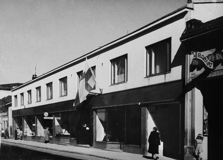 Vuonna 1940 valmistunut kaksikerroksinen liike-ja asuintalo sai vuonna 1954 kaksi lisäkerrosta. Kuva noin vuodelta 1950. Karjalan Puku Oy:n arkisto.